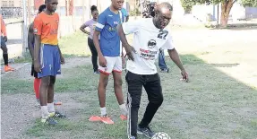  ?? IAN ALLEN/PHOTOGRAPH­ER ?? Holy Trinity High school’s football team coach Devon Anderson (right) doing a demonstrat­ion during a recent training session at the school’s playing field.