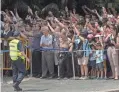  ??  ?? Curious onlookers wait for the motorcade of U.S. President Donald Trump in Singapore on Monday.