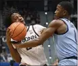  ?? JESSICA HILL — THE ASSOCIATED PRESS ?? UConn's Tristen Newton, left, who recorded a triple-double, is fouled by Marquette's Kam Jones on Tuesday.