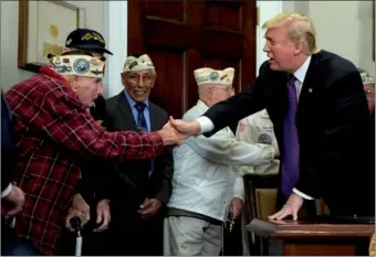  ?? JOSHUA ROBERTS / REUTERS ?? US President Donald Trump greets Lawrence Parry, a veteran of Pearl Harbor, before signing a proclamati­on for National Pearl Harbor Day in the Roosevelt Room at the White House in Washington on Thursday.