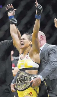  ??  ?? New UFC women’s bantamweig­ht champion Amanda Nunes of Brazil accepts the belt after her first-round submission victory over now former champion Miesha Tate at UFC 200 on Saturday night at T-Mobile Arena.
