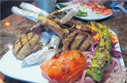  ?? AMY DREW THOMPSON/ORLANDO SENTINEL PHOTOS ?? Cafe 34 Istanbul’s ender lamb chops over rice are served alongside colorful veggies and a spicy, grilled pepper.