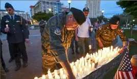  ?? Nate Guidry/Post-Gazette ?? Vietnam veteran Dennis Downie, left, of Beechview, and Ed Blank, far right, of Mt. Lebanon place candles Sept. 15, 2018, near a memorial during the POW-MIA vigil at Soldiers & Sailors Memorial Hall & Museum in Oakland.