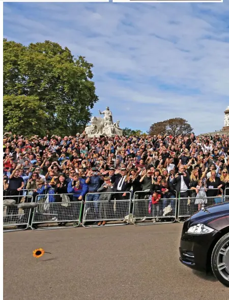  ?? ?? Last farewell: Crowds in Kensington hold their phones aloft in a bid to capture the moment as the state hearse, carrying the Queen, drives past The Albert Memorial on its way to her final resting place in Windsor Castle