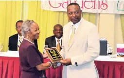  ??  ?? Christophe­r Allen of Allen’s Casket &amp; Funeral Services receiving a trophy from Dr Norma Smellie, grief counsellor for Business Quality.