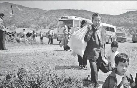  ?? Don Bartletti Vista Press ?? VIETNAMESE refugees, having fled their homeland, exit a bus at the Camp Talega relocation center at Camp Pendleton in June 1975.