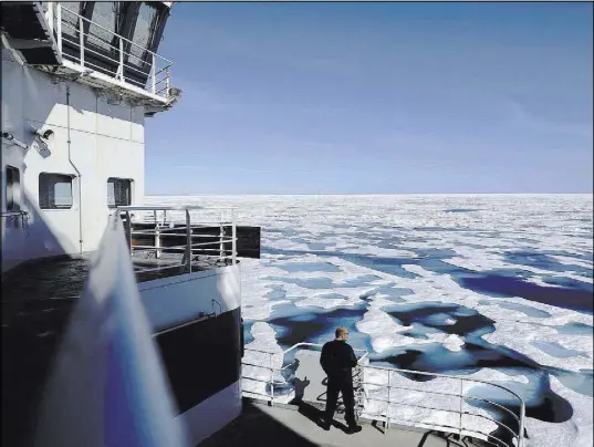  ?? David Goldman The Associated Press ?? Canadian coast guard Capt. Victor Gronmyr looks out July 22 over the ice covering the Victoria Strait as the Finnish icebreaker MSV Nordica traverses the Northwest Passage through the Canadian Archipelag­o.