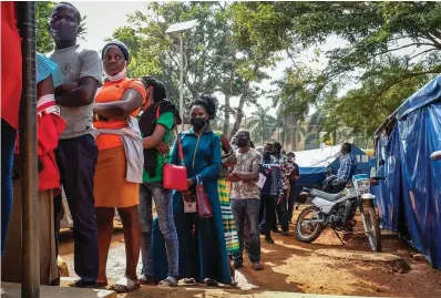  ?? The Associated Press ?? ■ Ugandans line up to receive Pfizer coronaviru­s vaccinatio­ns Feb. 8 at the Kiswa Health Centre III in the Bugolobi neighborho­od of Kampala, Uganda. In the latest Senate package targeted at stopping the coronaviru­s, U.S. lawmakers dropped nearly all funding for curbing the virus beyond its borders, in a move many health experts describe as dangerousl­y short-sighted. They warn the suspension of COVID aid for poorer countries could ultimately spur the kind of unchecked transmissi­on needed for the next worrisome variant to emerge.