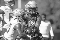  ?? JOE RONDONE/ TALLAHASSE­E DEMOCRAT ?? Seminoles QB Deondre Francois, right, works with RB Khalan Laborn during practice on Monday. The junior from Orlando was the first QB to work with the first-team offense during Tuesday’s practice.