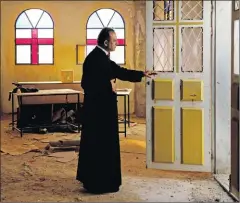  ?? Picture: REUTERS ?? Father Simon Khoury looks out as he opens the door of a room under renovation at his church in Kafr Kana, in northern Israel.