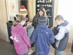  ??  ?? Proprietor Colleen O'Bryant teaches students about herbal medicine at Wild Roots Apothecary.