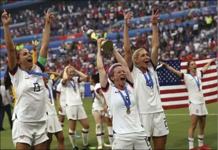  ?? AP PHOTO/FRANCISCO SECO ?? United States’ Megan Rapinoe (center) holds the trophy as she celebrates with teammates after they defeated the Netherland­s 2-0 in the Women’s World Cup final soccer match at the Stade de Lyon in Decines, outside Lyon, France, on Sunday.