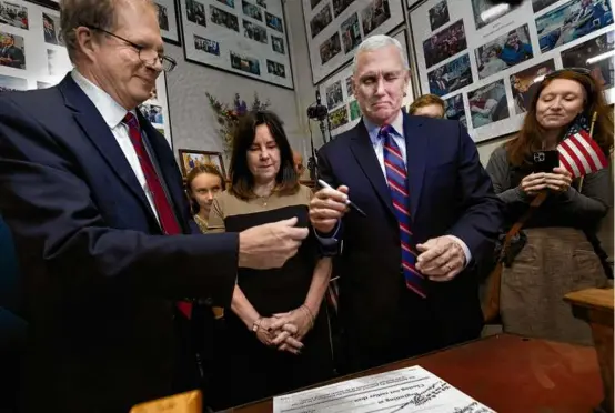  ?? MICHAEL DWYER/ASSOCIATED PRESS ?? Former vice president Mike Pence signed papers to get on New Hampshire’s Republican presidenti­al primary ballot next to his wife, Karen (second from left), and N.H. Secretary of State David Scanlan (left) at the State House, Friday, in Concord, N.H.