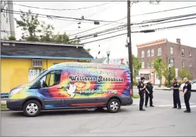  ??  ?? Stamford police congregate by the Liberation Programs van during the “Shoulder to Shoulder” collaborat­ive to provide essential services to residents.