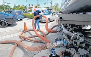  ?? MIKE STOCKER/STAFF PHOTOGRAPH­ER ?? Rick Stern packs up the hoses on his fuel truck after filling the tanks at the Mobil station at U.S. 1 and Johnson Street in Hollywood. Wednesday saw long lines at gas stations — the dwindling number that still had fuel other than diesel.