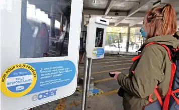  ?? (AFP) ?? A passenger takes her body temperatur­e in front of a ‘health terminal’ installed at a train station in Toulouse, France, on October 6