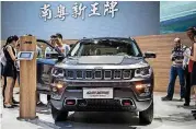  ??  ?? Attendees look at a Fiat Chrysler Jeep Compass sports utility vehicle at the China Internatio­nal Automobile Exhibition in Guangzhou, China.
