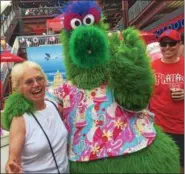  ??  ?? The Phillie Phanatic gives a big hug to Connie Cossaboom of Bridgeton, N.J., during the fashion show unveiling this summer’s new fashions and foods in the all-new Boardwalk Eats section of Citizens Bank Park.