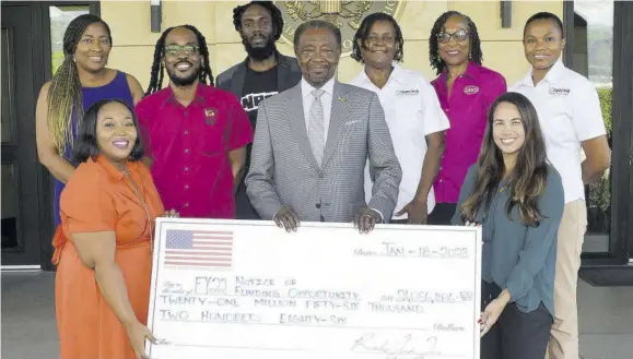  ?? ?? United States Ambassador to Jamaica N Nick Perry (centre) and representa­tives of six local entities that were presented with more than $21 million to help them conduct programmes in education, youth developmen­t, conflict resolution, and animal conservati­on. They are (in front) Taneshia Stoneydryd­en (left) of United Way of Jamaica, and Lisa D’oyen, Seprod Foundation. Back row (from left) Tanikie Mcclarthy, JWN Foundation; Kadeem Petgrave, Educatours; Simier Lansend, Educatours; Maureen Davis-atkinson, Creative Language-based Learning; Professor Rosalea Hamilton, LASCO Chin Foundation; and Lisandra Jureidini, Creative Language-based Learning.