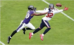  ?? AP Photo/Julio Cortez ?? ■ Houston Texans cornerback Lonnie Johnson (32) and Baltimore Ravens wide receiver Miles Boykin (80) reach for a ball thrown by Ravens quarterbac­k Lamar Jackson, not visible, during the first half Sunday in Baltimore.