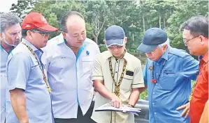  ??  ?? MASING (dua kanan), Nanta (kanan) serta yang lain semasa mendengar taklimat daripada pihak Jabatan Kerja Raya (JKR) dan kontraktor mengenai Jambatan Katibas.