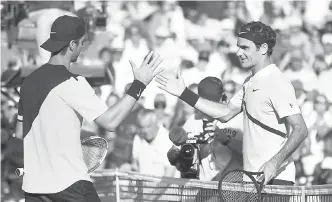  ?? — Gambar AFP ?? SEMANGAT KESUKANAN: Kokkinakis (kiri) berjabat tangan dengan Federer selepas tamat aksi perlawanan pusingan kedua Kejohanan Miami Masters di Florida.