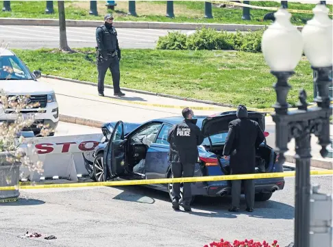  ??  ?? RAMPAGE: US Capitol Police officers stand near a car that crashed into a barrier on Capitol Hill in Washington DC.