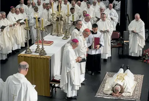  ?? PHOTO: IAIN McGREGOR/STUFF ?? Pomp and ceremony . . . Paul Martin lies prostrate during his ordination as 10th bishop of the Catholic diocese of Christchur­ch at the weekend.