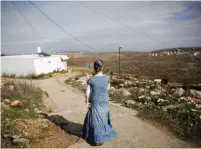  ?? (Ronen Zvulun/Reuters) ?? A JEWISH WOMAN walks near her house in the outpost of Ahiya, south of Nablus.