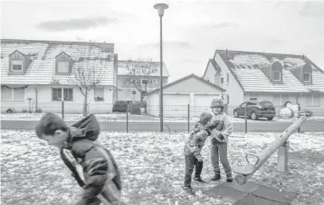  ?? LAETITIA VANCON/THE NEW YORK TIMES ?? Above, children on a playground Dec. 5 at an off-post village community for American soldiers and their families near Vilseck, Germany. American culture, friends and jobs are part of the fabric of Vilseck.