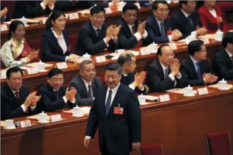  ?? AP PHOTO/ANDY WONG ?? Delegates applaud as Chinese President Xi Jinping walks to his seat after casting his vote for an amendment to China’s constituti­on that will abolish term limits on the presidency and enable him to rule indefinite­ly, during a plenary session of the...