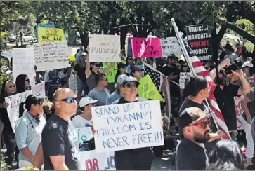  ?? Cedar Attanasio Associated Press ?? PROTESTERS against COVID-19 vaccine and mask mandates demonstrat­e in Santa Fe, N.M., in August. The social trends that have pushed Americans apart for 20 years go far deeper than any president can reach.