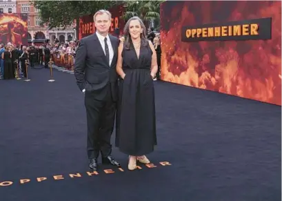  ?? VIANNEY LE CAER/INVISION ?? Director Christophe­r Nolan, left, and producer Emma Thomas pose for photograph­ers upon arrival at the premiere for the film “Oppenheime­r” on July 13 in London.