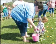  ?? Photo by Susan Holland ?? Cora Williams, 17 months old, was fascinated by all the brightly colored eggs at Saturday’s Easter Eggstravag­anza. When the hunt for children 2 year old and younger began, she went right to work collecting several eggs while her mother held her basket....