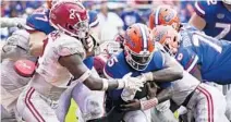  ?? JOHN RAOUX/AP ?? Florida quarterbac­k Emory Jones pushes through a pack of Alabama defenders during a 5-yard touchdown run Saturday.