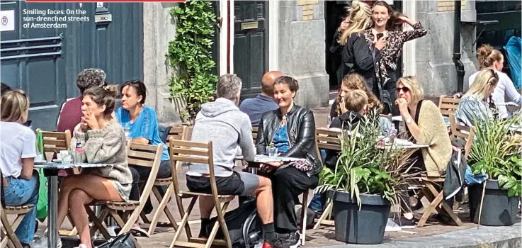  ??  ?? Smiling faces: On the sun-drenched streets of Amsterdam