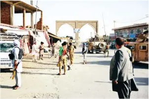  ?? AFP ?? Afghan security forces and militia stand along a road during clashes between Taliban militants and Afghan security forces in Ghazni province on Sunday.