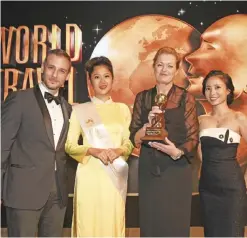  ??  ?? MELBOURNE: Etihad Airways’ General Manager for Australia and New Zealand, Sarah Built, accepts the award for Australasi­a’s Leading Airport Lounge from event hosts Greg Ohan (left) and Mai Anh Du (right).