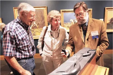  ?? PHOTO BY K.T. KING, THE OKLAHOMAN ?? Phil Shanley, Barbara Hadley, owners of Evergreen Fine Art Gallery in Evergreen, Colo., look at artist Steve Kestrel’s sculpture, “Desert Timeline” on Saturday at the National Cowboy & Western Heritage Museum in Oklahoma City.
