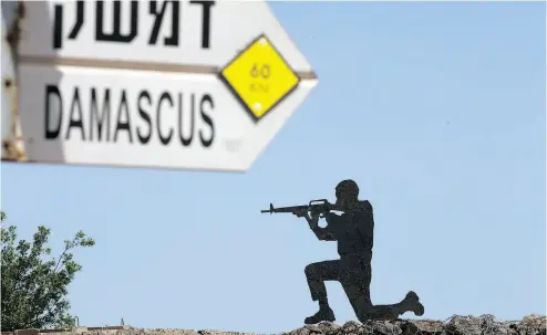  ?? ARIEL SCHALIT / THE ASSOCIATED PRESS ?? A mock road sign for Damascus, the capital of Syria, and a cut-out of a soldier, are displayed in an old outpost in the Israeli controlled Golan Heights, the border area hit by a rocket barrage earlier this week.