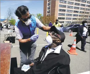  ?? Matthew Brown / Hearst Connecticu­t Media ?? Dr. J.D. Sidana of DOCS Urgent Care Stamford administer­s a COVID-19 nasal swab test to Robert Hayes, 73, of Stamford, at a walk-up testing site at AME Bethel Church in Stamford on May 2.