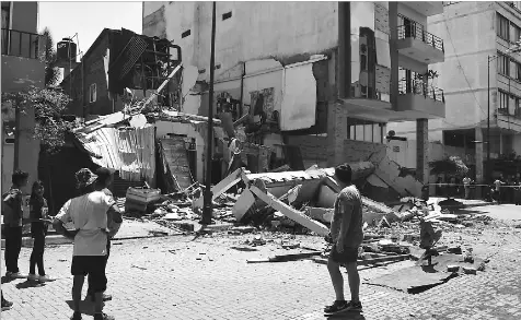  ?? Jhonny Crespo/The Associated Press ?? Residents looked at a building that collapsed after an earthquake shook southern Ecuador and northern Peru on Saturday. Officials reported a quake with a magnitude of about 6.8, centered just off the Pacific Coast.