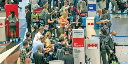  ?? ?? People line up to get on the Air France flight to Paris at or Tambo Internatio­nal Airport in Johannesbu­rg, South Africa, Friday on November 26, 2021.