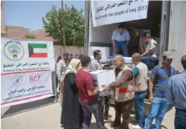  ??  ?? KRCS workers distribute aid to displaced Iraqis in Mosul.