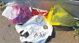  ??  ?? Football shirts and floral tributes were left outside a house; below, police at the scene