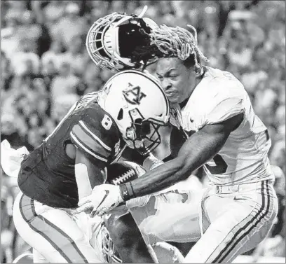  ?? BUTCH DILL/AP ?? Alabama defensive back Xavier McKinney, right, loses his helmet as Auburn running back Shaun Shivers runs through him Saturday.