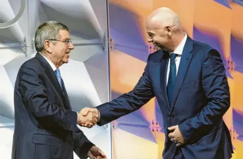  ?? Foto: Gillieron, dpa ?? Diese Herren lenken die Geschicke des Weltsports. Thomas Bach (links) ist der Präsident des Internatio­nalen Olympische­n Komitees. Gianni Infantino ist der Präsident des Fußball‰Weltverban­des. Momentan allerdings herrscht zwischen den beiden Eiszeit. Es geht um die Fifa‰Pläne, die Fußball‰WM alle zwei Jahre zu spielen.