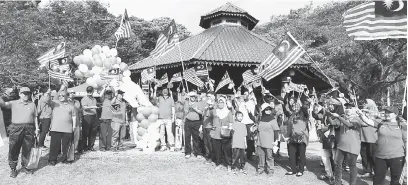  ??  ?? BESEMANGAT: Temuai sereta ngitau Jalur Gemilang kelai bejadika Program Merdeka@ Komuniti, Kimpin Nuat Jalur Gemilang.