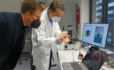  ?? FOTO: CASJEN CARL ?? Jürgen Hess vom Fraunhofer-Zentrum für Mikroelekt­ronische und Optische Systeme für die Biomedizin in Erfurt zeigt dem Ost-Beauftragt­en der Bundesregi­erung, Carsten Schneider, ein neuartiges Mikroskop.