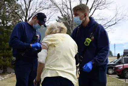  ?? Hyoung Chang, The Denver Post ?? Misko Pazsgai, left, and Brian Steen of South Metro Fire Rescue take care of a fallen and injured senior in Centennial on March 24. Transports by ambulance fell by 800 in 2020 as people worried about seeking help in medical emergencie­s.